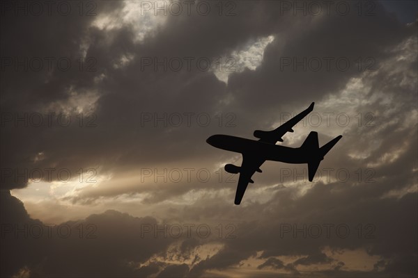 Commercial jet in cloudy sky. Photo. Mike Kemp