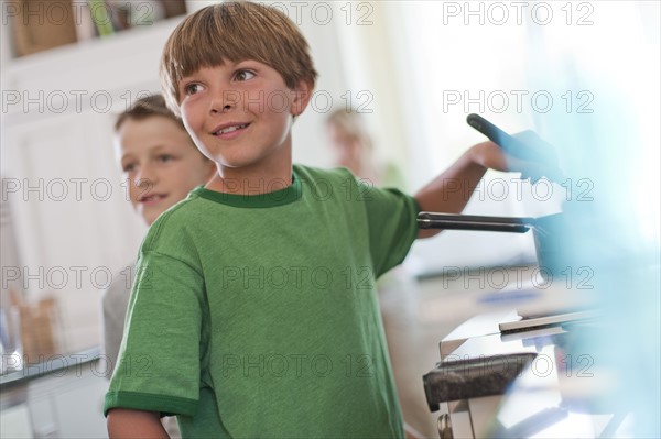 Young boy stirring food on stove. Photo : Tim Pannell