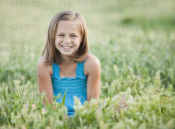 Young girl sitting in field. Photo : Mike Kemp