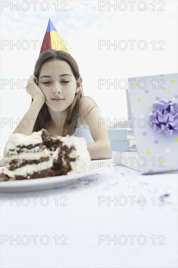 Young girl staring at birthday cake. Photo. momentimages