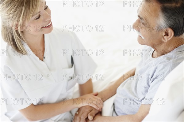 Nurse sitting with patient. Photo : momentimages