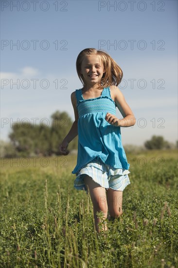 Young girl running in field. Photo : Mike Kemp