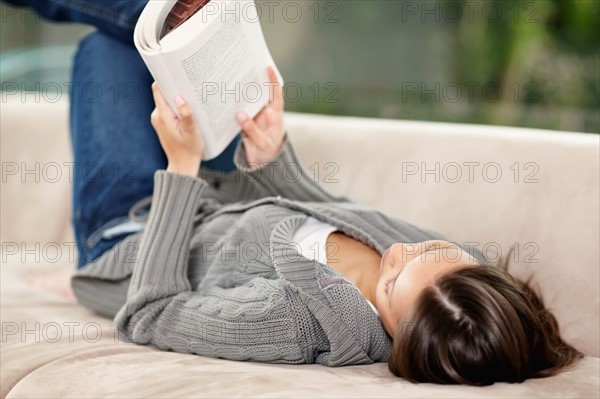 Brunette woman relaxing and reading. Photo : momentimages