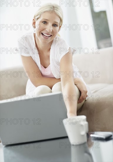 Pretty blond woman browsing the internet. Photo : momentimages