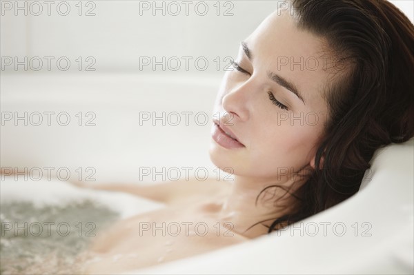 Woman relaxing in bathtub. Photo. momentimages