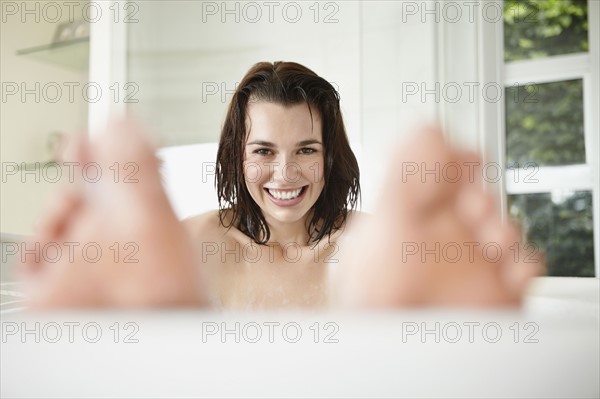 Cheerful woman in bathtub. Photo. momentimages