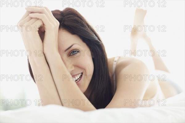 Sexy woman lying on bed. Photo : momentimages