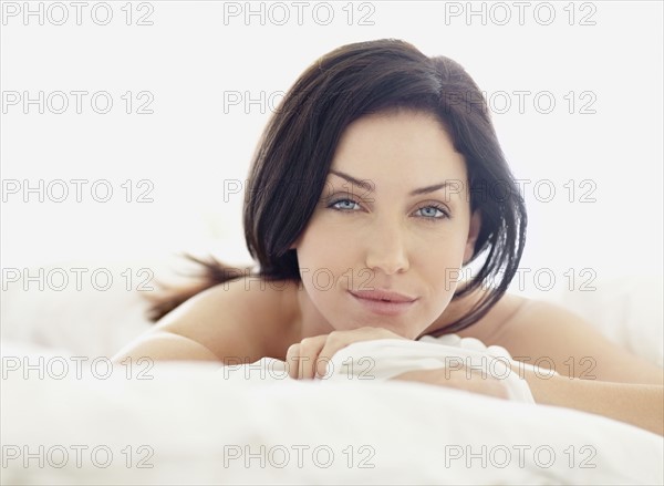 Sexy woman lying on bed. Photo : momentimages