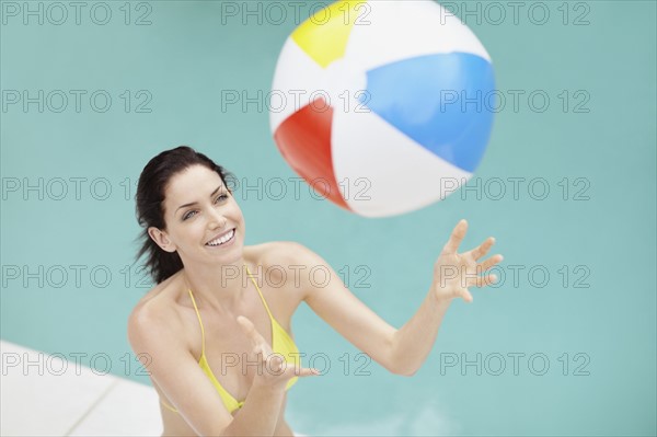 Attractive brunette playing with a beach ball. Photo. momentimages