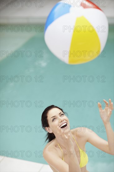 Attractive brunette playing with a beach ball. Photo. momentimages