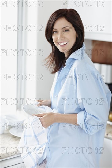 Attractive brunette drying the dishes. Photo. momentimages