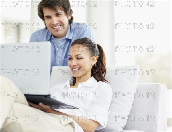 Couple looking at laptop. Photo. momentimages