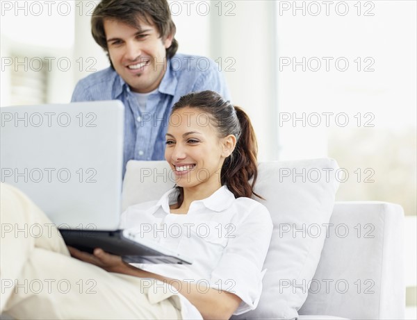 Couple looking at laptop. Photo : momentimages