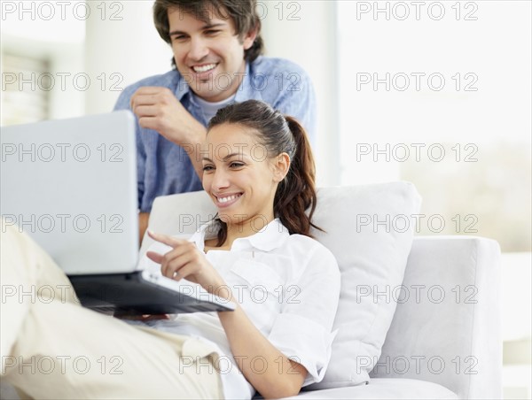 Couple looking at laptop. Photo. momentimages