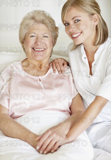 Nurse sitting with a senior woman. Photo. momentimages