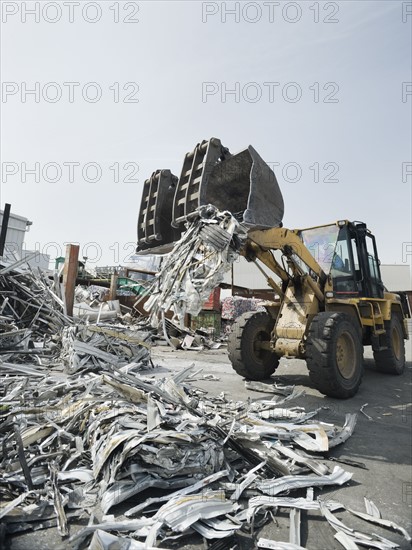 Backhoe lifting recycled metal. Photo. Erik Isakson