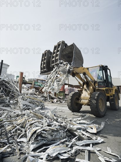 Backhoe lifting recycled metal.