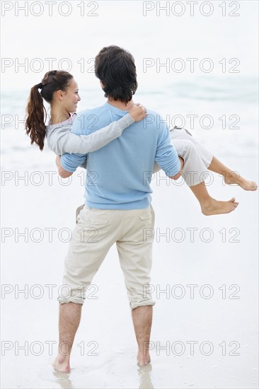 Playful couple at the beach. Photo. momentimages