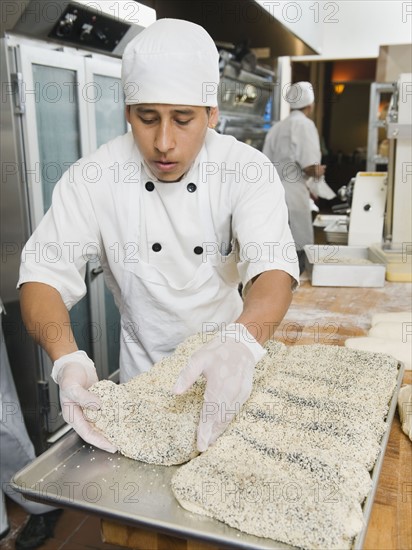 Chef making bread in bakery.