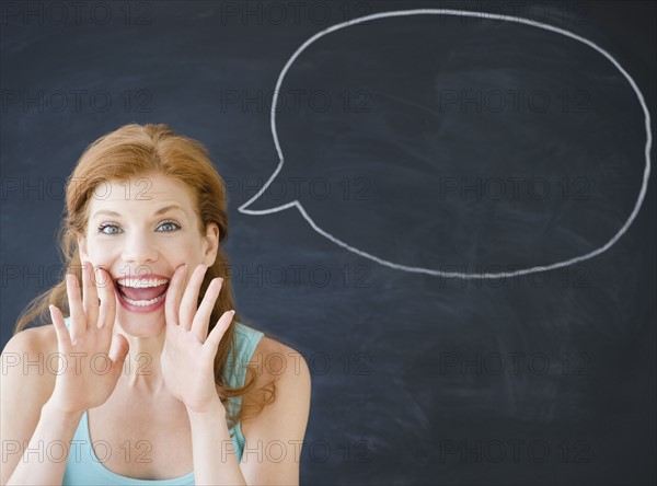 Woman standing in front of a speech bubble. Photo : Jamie Grill