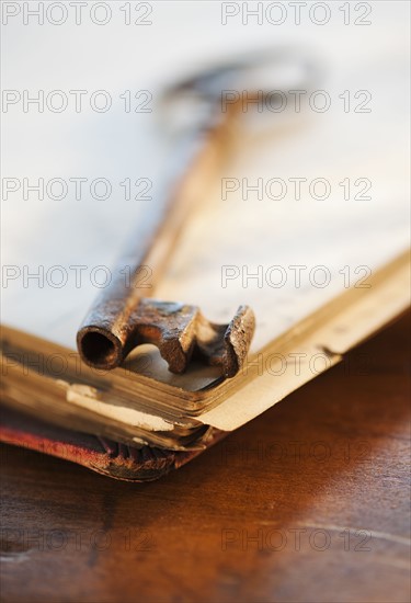 Antique key on top of book.