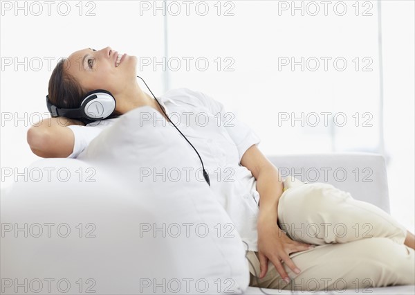 Woman listening to music on headphones. Photo. momentimages