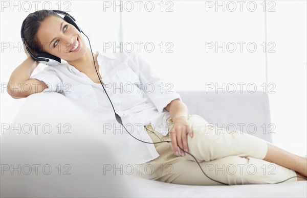 Woman listening to music on headphones. Photo. momentimages