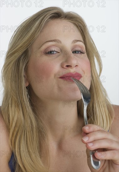 Blond woman holding a fork.