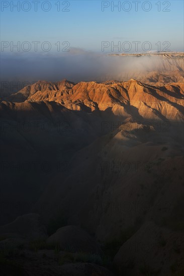 USA, South Dakota, Mountains in morning fog in Badlands National Park.