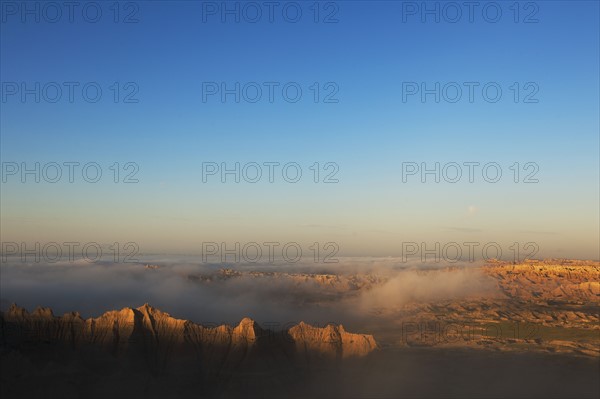 USA, South Dakota, Mountains in morning fog in Badlands National Park.