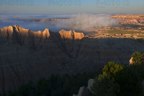 USA, South Dakota, Mountains in morning fog in Badlands National Park.