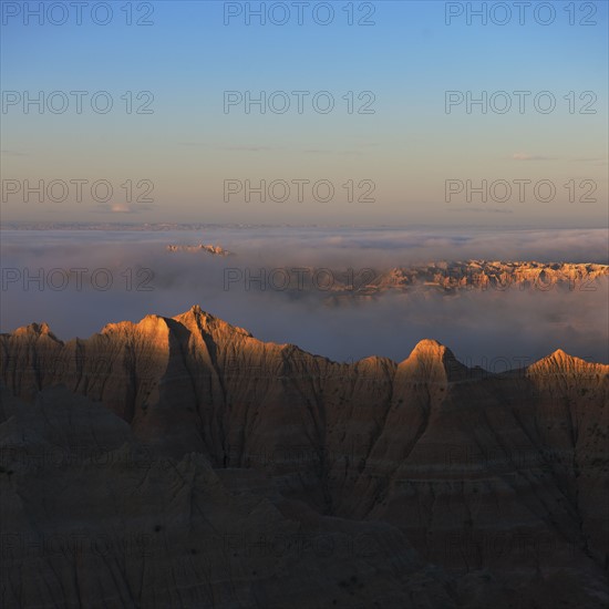 USA, South Dakota, Mountains in morning fog in Badlands National Park.