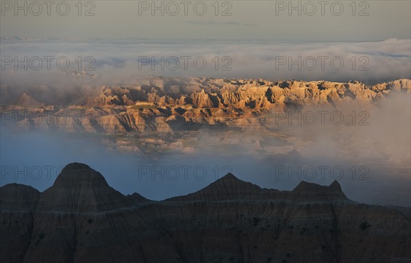 USA, South Dakota, Mountains in morning fog in Badlands National Park.