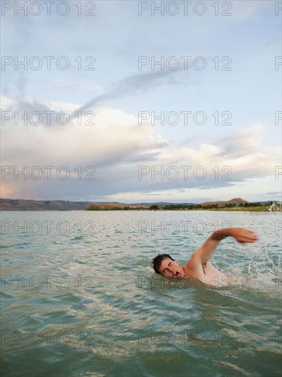 Man swimming in lake.