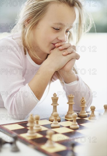 Girl (10-11) playing chess. Photo : Momentimages