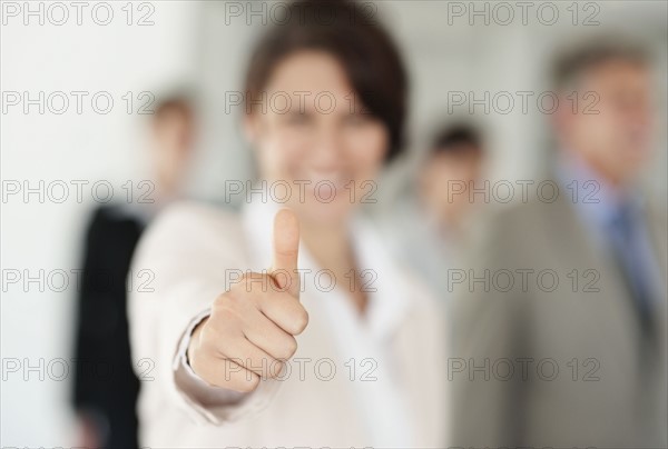 Businesswoman with thumbs-up. Photo : Momentimages