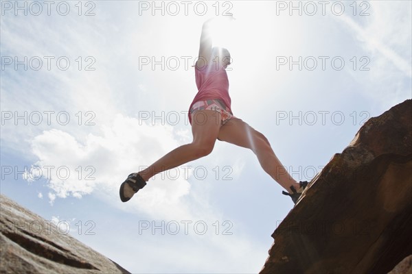Young woman jumping on rocks. Photo : Johannes Kroemer
