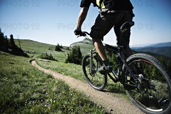 Man mountain biking on mountain track. Photo : Shawn O'Connor