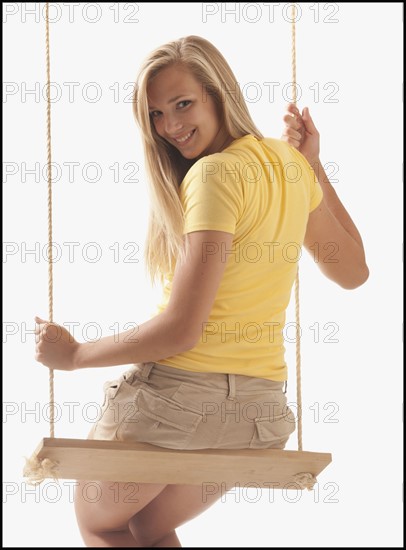 Portrait of young girl (16-17) on swing. Photo : Mike Kemp