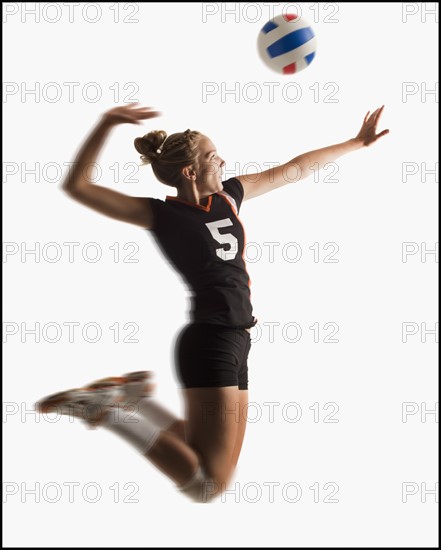 Young girl (16-17) playing volleyball. Photo : Mike Kemp