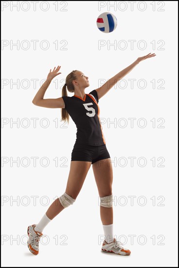 Young girl (16-17) playing volleyball. Photo : Mike Kemp