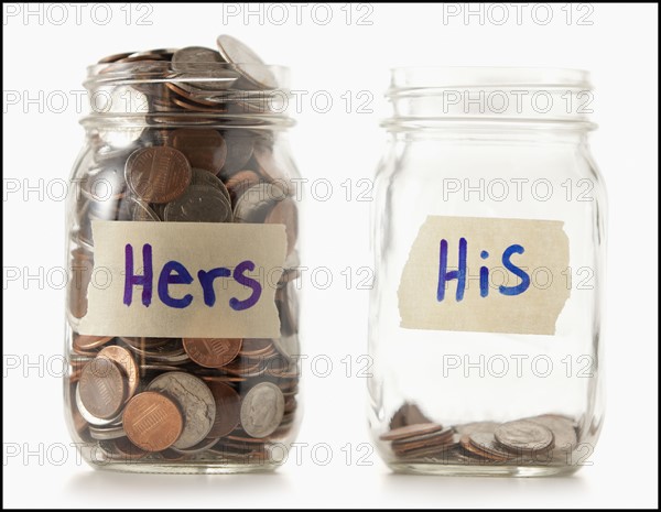 Studio shot of two jars with coins labeled "Hers" and "His". Photo : Mike Kemp