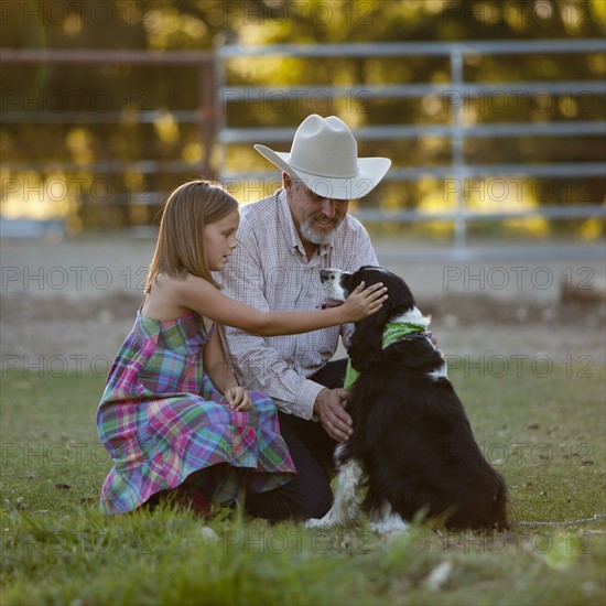 Girl (8-9) stroking dog with grandfather. Photo : Mike Kemp
