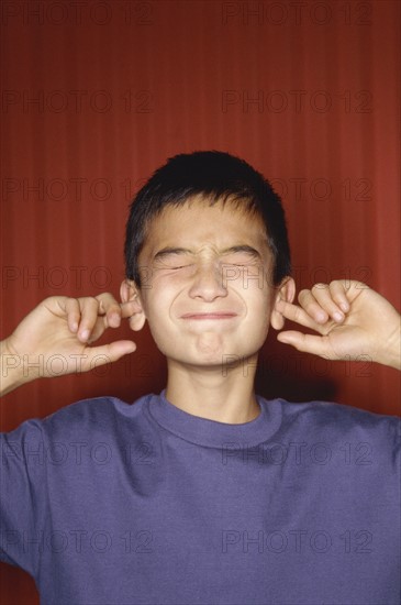 Young boy sticking his fingers in his ears. Photo : Fisher Litwin