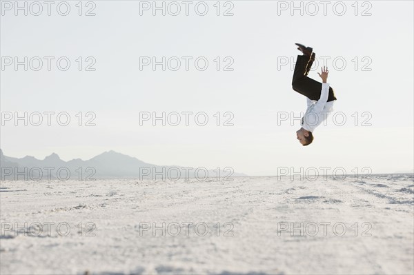 Young man doing backflip in desert. Photo : FBP