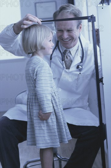 Doctor measuring young girl's growth. Photo : Fisher Litwin