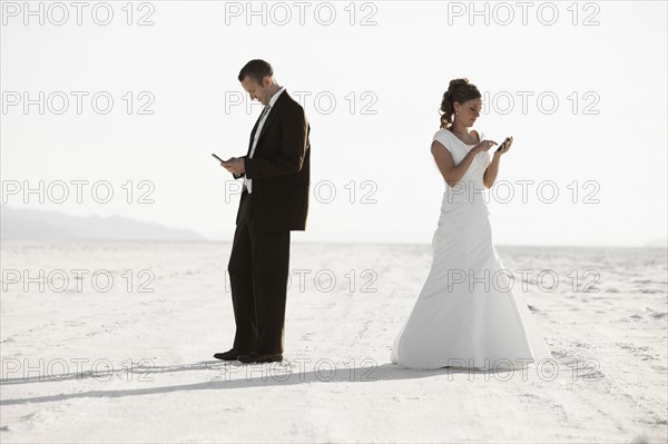 Bride and groom texting in desert. Photo : FBP