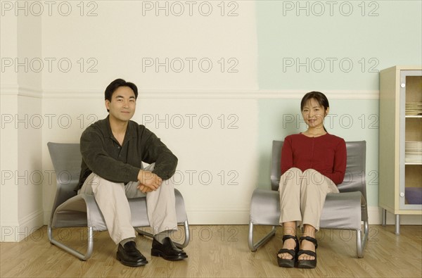 Couple sitting in a pair of matching chairs. Photo : Fisher Litwin