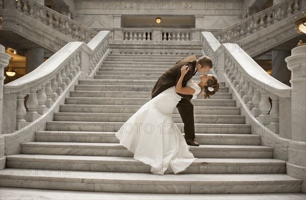 Bride and groom embracing on steps. Photo : FBP