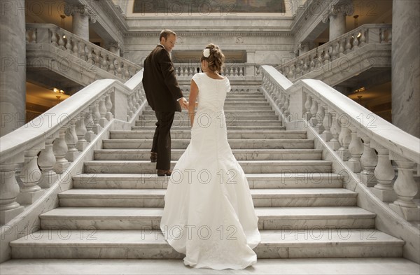 Bride and groom holding hands on steps. Photo : FBP